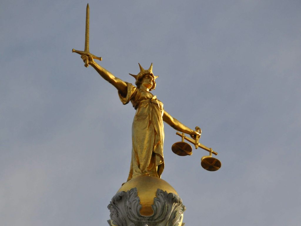 Lady Justice atop the Old Bailey in London as, while ministers push to loosen rules to speed up AI adoption, The Law Society argues that lawyers just need to know how current laws apply.